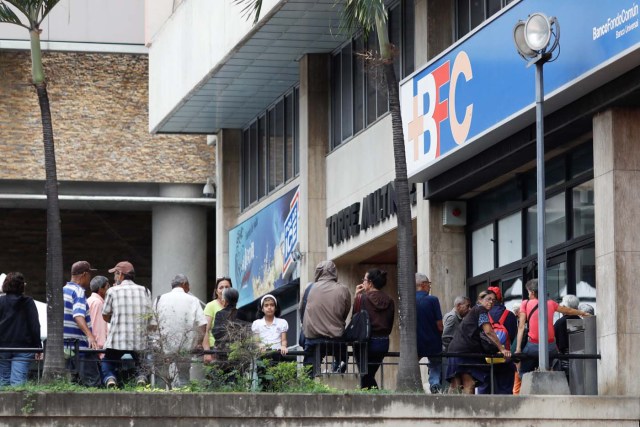 People queue to withdraw cash from an ATM outside a Banco BFC branch in Caracas, Venezuela November 13, 2017. REUTERS/Marco Bello