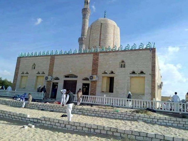 EPA077. ARISH (EGIPTO), 24/11/2017.- Varias personas permanecen en el exterior de una mezquita contra la que se ha perpetrado un ataque, en la ciudad de Al Arish, en el norte de la península del Sinaí (Egipto), hoy 24 de noviembre de 2017. Al menos 54 personas murieron y 75 resultaron heridas en el ataque terrorista, informó hoy la agencia oficial de noticias, MENA. Los atacantes colocaron artefactos explosivos de fabricación casera alrededor de la mezquita y los hicieron detonar a la salida de los fieles del rezo del viernes, el día sagrado para los musulmanes, indicó una fuente de seguridad a Efe, que añadió que las personas que pudieron escapar fueron tiroteadas por los extremistas. EFE/ Str MEJOR CALIDAD DISPONIBLE