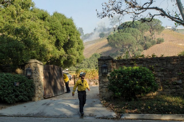 A firefighter walks out of a vineyard owned by Rupert Murdoch damaged by the Skirball fire near the Bel Air neighborhood on the west side of Los Angeles, California, U.S., December 6, 2017.      REUTERS/Andrew Cullen