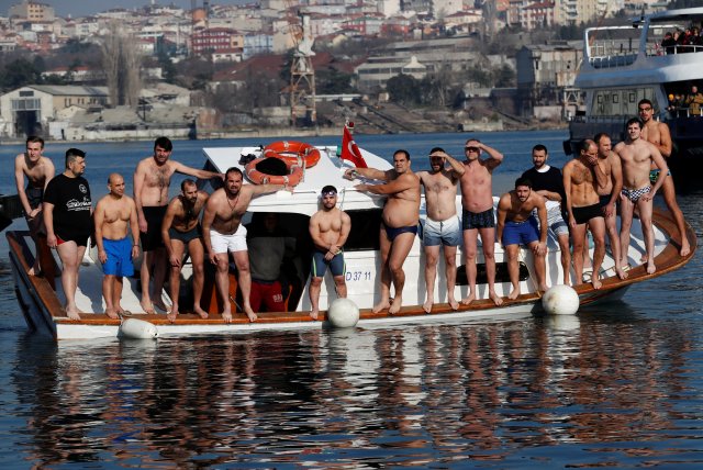 Greek Orthodox faithful wait for the Greek Orthodox Ecumenical Patriarch Bartholomew I (not pictured) to throw a wooden crucifix into the Golden Horn in Istanbul, Turkey, January 6, 2018. REUTERS/Murad Sezer