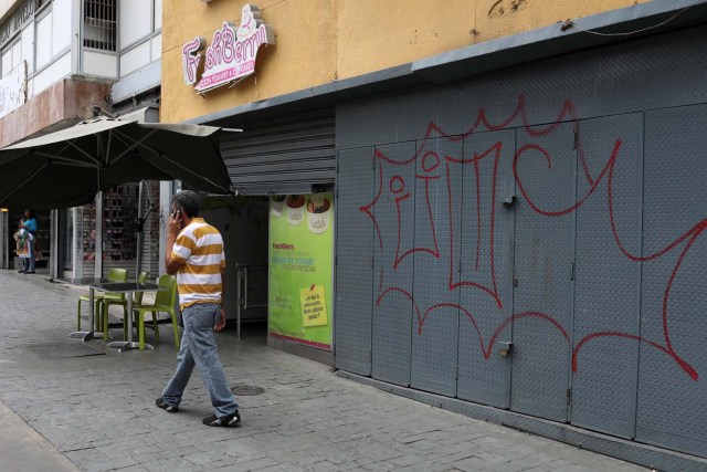 A man walks past reinforced security gates at a store in downtown Caracas, Venezuela January 16, 2018. Picture taken January 16, 2018. REUTERS/Marco Bello