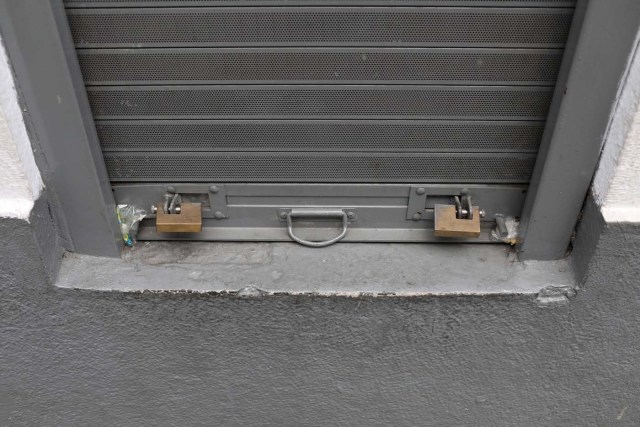 A security shutter with padlocks is seen on a window at a cafe in Caracas, Venezuela January 16, 2018. Picture taken January 16, 2018. REUTERS/Marco Bello