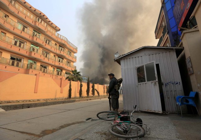 An Afghan policeman stands guard at the site of a blast and gun fire in Jalalabad, Afghanistan January 24, 2018.REUTERS/Parwiz