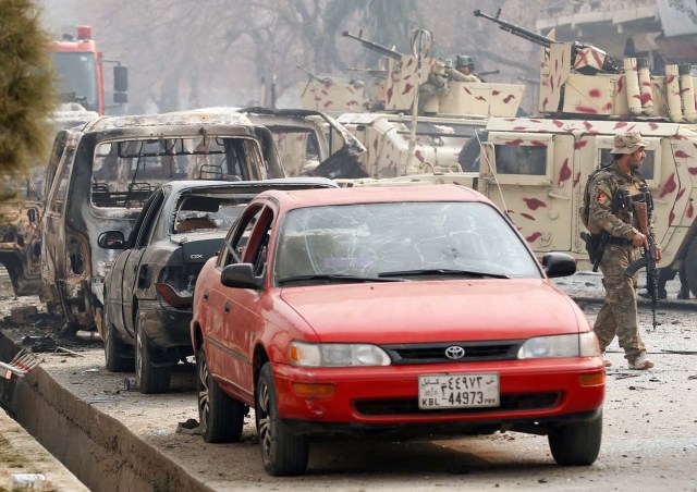 An Afghan security force officer walks past damaged vehicles at the site of a blast and gun fire in Jalalabad, Afghanistan January 24, 2018.REUTERS/Parwiz