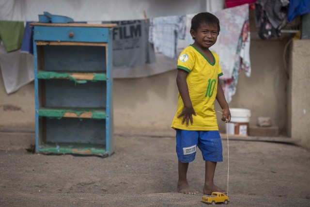 Venezuelan refugee child from Warao indigenous tribe plays with a toy inside a shelter in the city of Boa Vista, Roraima, Brazil, on February 24, 2018. According with local authorities, around one thousand refugees are crossing the Brazilian border each day from Venezuela. With the constant influx of Venezuelan immigrants most are living in shelters and the streets of Boa Vista and Paracaima cities, looking for work, medical care and food. Most are legalizing their status to stay and live in Brazil. / AFP PHOTO / MAURO PIMENTEL