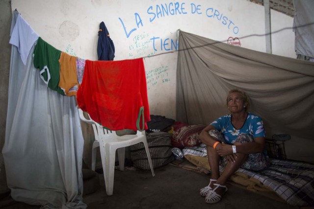 Maria Flores, 50, who works as housekeeper to send money to her family in Venezuela, sits inside a shelter in the city of Boa Vista, Roraima, Brazil, on February 24, 2018. According with local authorities, around one thousand refugees are crossing the Brazilian border each day from Venezuela. With the constant influx of Venezuelan immigrants most are living in shelters and the streets of Boa Vista and Paracaima cities, looking for work, medical care and food. Most are legalizing their status to stay and live in Brazil. / AFP PHOTO / MAURO PIMENTEL