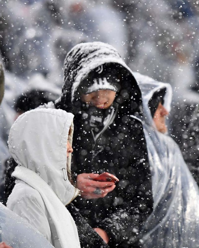 Supporters look on under heavy snowfall before the postponed Italian Serie A football match Juventus versus Atalanta on February 25, 2018 at the Allianz Stadium in Turin. The Italian Serie A football match Juventus versus Atalanta on February 25 has been postponed due to weather. / AFP PHOTO / ALBERTO PIZZOLI