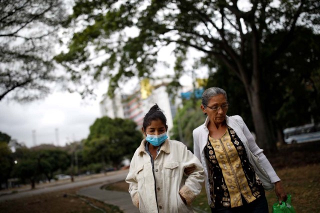 Yasmira Castano (L), 40, who lost her transplanted kidney, walks helped by her mother after she received a dialysis session at a state hospital in Caracas, Venezuela February 14, 2018. Castano was unable to find the drugs needed to keep her body from rejecting the organ. On Christmas Eve 2017, she was rushed to a state hospital. Her immune system had attacked the foreign organ and she lost her kidney shortly afterwards. Picture taken February 14, 2018. REUTERS/Carlos Garcia Rawlins