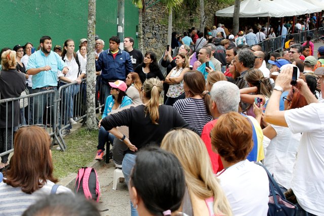 David Smolansky (izq., En celeste), alcalde de El Hatillo, habla con la gente reunida frente a un centro de validación durante la segunda fase del Consejo Nacional Electoral de Venezuela (CNE) para verificar firmas para un referéndum revocatorio contra el presidente Nicolás Maduro en Caracas, Venezuela 24 de junio de 2016. REUTERS / Marco Bello / Foto de archivo