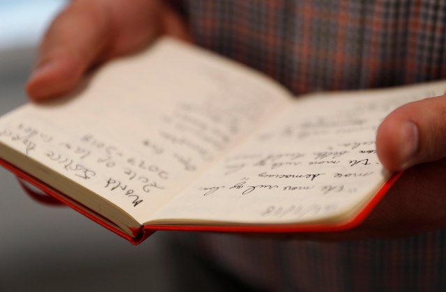 David Smolansky displays his notebook which he uses for everything he needs to organize in his immediate life while posing for a portrait in his office in Washington, U.S., February 22, 2018. Picture taken February 22, 2018. REUTERS/Leah Millis