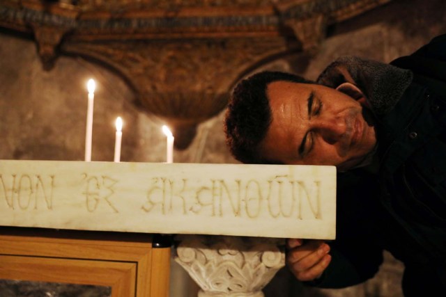 A worshipper places his head on an altar in the Church of the Holy Sepulchre in Jerusalem's Old City, February 28, 2018. REUTERS/Ammar Awad