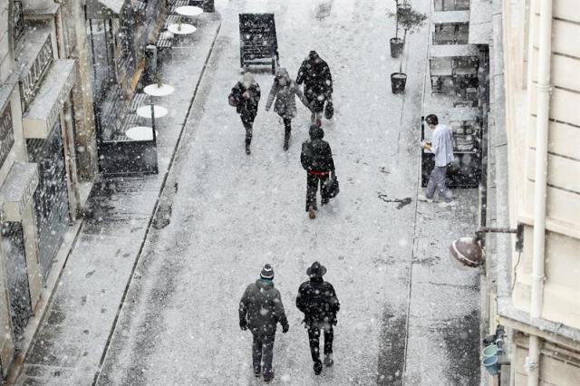  Varios peatones caminan por una calle cubierta por una fina capa de nieve en París (Francia), hoy 27 de febrero de 2018. Varias partes de Europa se vieron azotadas por una ola de frío extremo que trajo una bajada de las temperaturas no vistas desde hace 10 años. EFE/ Yoan Valat