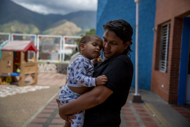  En una visita a Fundana un domingo, Melani Morales abraza a su hijo Christopher, a quien ella colocó allí porque no puede permitirse cuidarlo. (Alejandro Cegarra for The Washington Post)