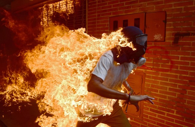 En esta foto de archivo tomada el 3 de mayo de 2017 Un manifestante se incendia durante los enfrentamientos con la policía antidisturbios en una protesta contra el presidente venezolano, Nicolás Maduro. Una imagen abrasadora de un manifestante venezolano que se incendió durante los enfrentamientos con la policía antidisturbios ha ganado al fotógrafo de AFP Ronaldo Schemidt una nominación para el premio World Press Photo 2018. El pargo con sede en México de Agence France-Presse se encuentra entre los seis fotógrafos, elegidos entre más de 4.500 aspirantes, para ser nominados para el prestigioso premio anual, la World Press Photo Foundation en Amsterdam reveló el 14 de febrero de 2018. / AFP PHOTO / RONALDO SCHEMIDT