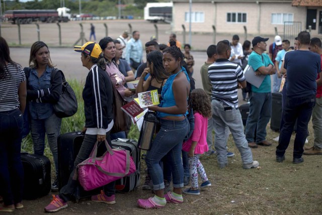 Venezuelans wait in a queue in front of the Brazil Federal Police Office in the Venezuela-Brazil border, at Pacaraima, Roraima, Brazil, on February 28, 2018. According to local authorities, around one thousand refugees are crossing the Brazilian border each day from Venezuela. With the constant influx of Venezuelan immigrants, most are living in shelters and the streets of Boa Vista and Pacaraima cities, looking for work, medical care and food. Most are legalizing their status to stay and live in Brazil. / AFP PHOTO / Mauro Pimentel / TO GO WITH AFP STORY by Paula RAMÓN