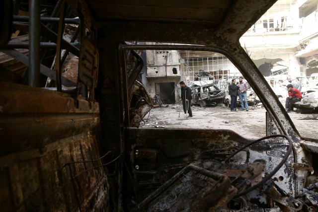 A man on crutches walks at a damaged site in the besieged town of Douma, Eastern Ghouta, in Damascus, Syria March 21, 2018. REUTERS/Bassam Khabieh