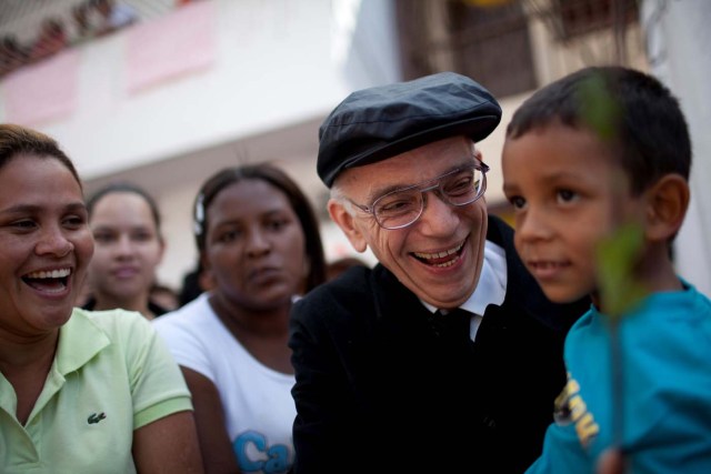 FILE PHOTO: Founder of the National System of Youth and Children's Orchestras of Venezuela Jose Antonio Abreu carries a child as he arrives at a free concert at the low-income neighborhood of La Vega in Caracas August 2, 2009.   REUTERS/Carlos Garcia Rawlins/File Photo