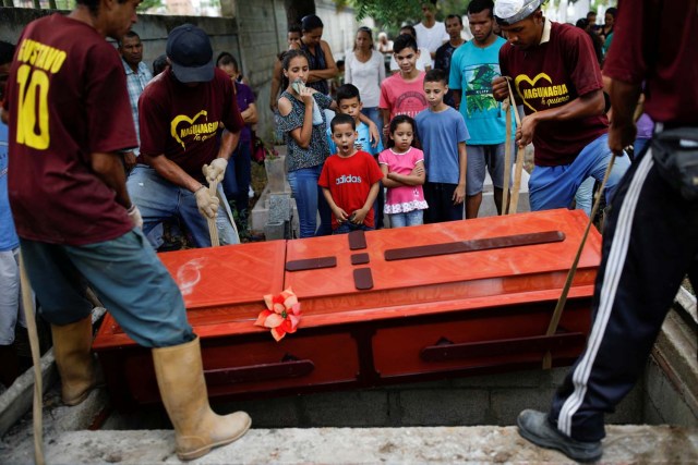 Familiares de Javier Rivas, uno de los presos que murieron durante un motín y un incendio en las celdas del Comando General de la Policía de Carabobo, reaccionó frente a su camino durante su funeral en Valencia, Venezuela el 29 de marzo de 2018. REUTERS / Carlos Garcia Rawlins