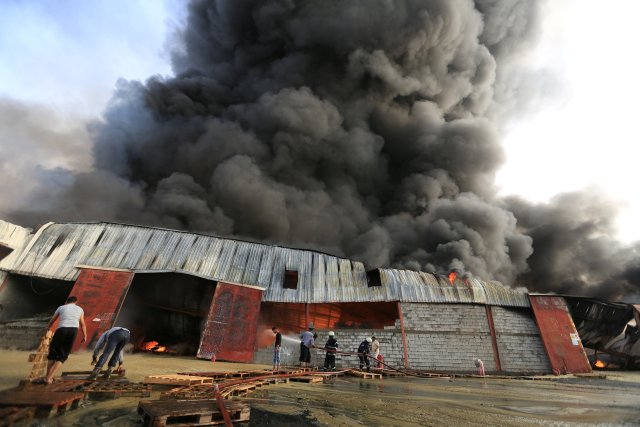 Firefighters try to extinguish a fire engulfing warehouse of the World Food Programme in Hodeida, Yemen March 31, 2018. REUTERS/Abduljabbar Zeyad