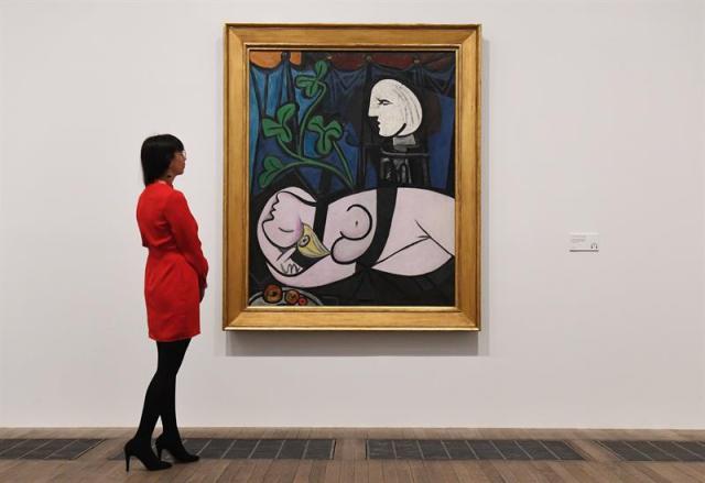 Una empleada del museo observa la obras de Pablo Picasso "Desnudo, hojas verdes y busto", de 1932, expuesta en el ámbito de la exposición inaugurada en la Tate Modern de Londres (Reino Unido) hoy, 6 de marzo de 2018. EFE/ Andy Rain