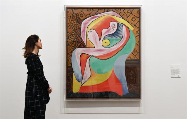 Una empleada del museo observa la obra de Pablo Ruiz Picasso "El Reposo", de 1932, expuesta en el ámbito de la exposición inaugurada en la Tate Modern de Londres (Reino Unido) hoy, 6 de marzo de 2018. EFE/ Andy Rain