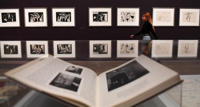 Una empleada del museo pasa delante de varias obras de Pablo Ruiz Picasso expuestas en el ámbito de la exposición inaugurada en la Tate Modern de Londres (Reino Unido) hoy, 6 de marzo de 2018. EFE/ Andy Rain