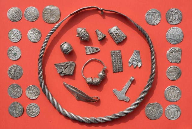 Parts of the silver treasure are pictured on a table in Schaprode, northern Germany on April 13, 2018. A 13-year-old boy and a hobby archaeologist have unearthed a "significant" trove in Germany which may have belonged to the legendary Danish king Harald Bluetooth who brought Christianity to Denmark. A dig covering 400 square metres (4,300 square feet) that finally started over the weekend by the regional archaeology service has since uncovered a trove believed linked to the Danish king who reigned from around 958 to 986. Braided necklaces, pearls, brooches, a Thor's hammer, rings and up to 600 chipped coins were found, including more than 100 that date back to Bluetooth's era. / AFP PHOTO / dpa / Stefan Sauer / Germany OUT
