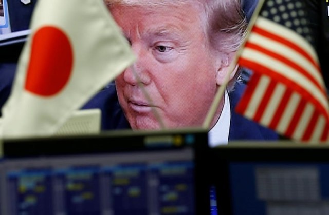 En la imagern de archivo un monitor de televisión muestra al presidente estadounidense Donald Trump detrás de las banderas nacionales de EE. UU. Y Japón en una empresa comercializadora de divisas en Tokio, Japón, el 1 de febrero de 2017. REUTERS / Kim Kyung-Hoon