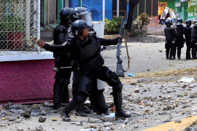 Un policía antidisturbios arroja una piedra contra los estudiantes universitarios durante una protesta contra las reformas que implementan cambios en los planes de pensiones del Instituto Nicaragüense de Seguridad Social (INSS) en Managua, Nicaragua, abril 19,2018.REUTERS / Oswaldo Rivas