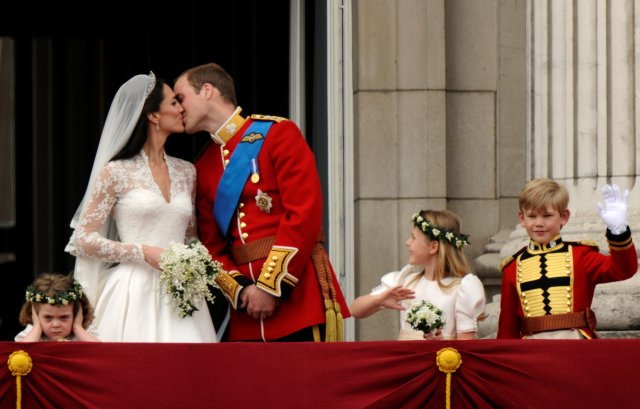 El príncipe Guillermo y su esposa Catherine, duquesa de Cambridge se besan en el balcón del Palacio de Buckingham, observados por sus novias Grace van Cutsem (L) y Margarita Armstrong-Jones y el poeta Tom Pettifer, después de su boda en Westminster Abbey, en el centro de Londres 29 de abril , 2011. REUTERS / Dylan Martinez / Foto de archivo