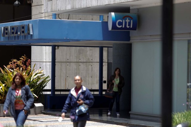 People walk outside a branch of Citi bank in Caracas, Venezuela April 6, 2018. REUTERS/Marco Bello