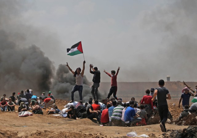 Los palestinos agitan su bandera nacional mientras se manifiestan cerca de la frontera entre Israel y la Franja de Gaza, al este de Jabalia, en contra de la inauguración de la embajada de los Estados Unidos tras su controvertido traslado a Jerusalén el 14 de mayo de 2018. / AFP PHOTO / MOHAMMED ABED