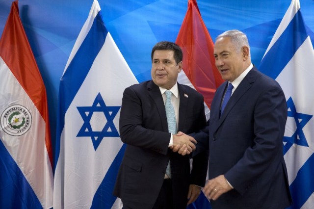 Israeli Prime Minister Benjamin Netanyahu (R) shakes hands with Paraguayan President Horacio Cartes during their meeting at the Prime Minister's office in Jerusalem on May 21, 2018. Paraguay followed the US and Guatemala to inaugurate its new embassy in Jerusalem on May 21. / AFP PHOTO / POOL / Sebastian Scheiner