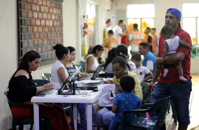 CUC04. CÚCUTA (COLOMBIA), 04/05/2018.- Un grupo de venezolanos recibe asistencia en Cúcuta (Colombia) este 3 de mayo de 2018. Bajo el sol intenso de la ciudad colombiana de Cúcuta, cientos de familias venezolanas que huyeron de su país por la crisis económica y política hacen fila para reclamar los bonos alimentarios que entrega el Programa Mundial de Alimentos (PMA) de la ONU en las zonas de frontera. El proyecto que comenzó este lunes en Cúcuta, capital de Norte de Santander, surge como la primera gran respuesta de la comunidad internacional al delicado estado alimentario del 90 % de los cerca de 35.000 venezolanos que cruzan a diario las fronteras con Colombia en busca de oportunidades. EFE/SCHNEYDER MENDOZA