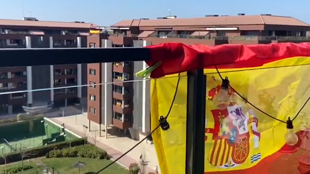 ¡Conmovedor! Con banderas en los balcones y escuchando el himno, los españoles resisten el estado de alarma (VIDEO)